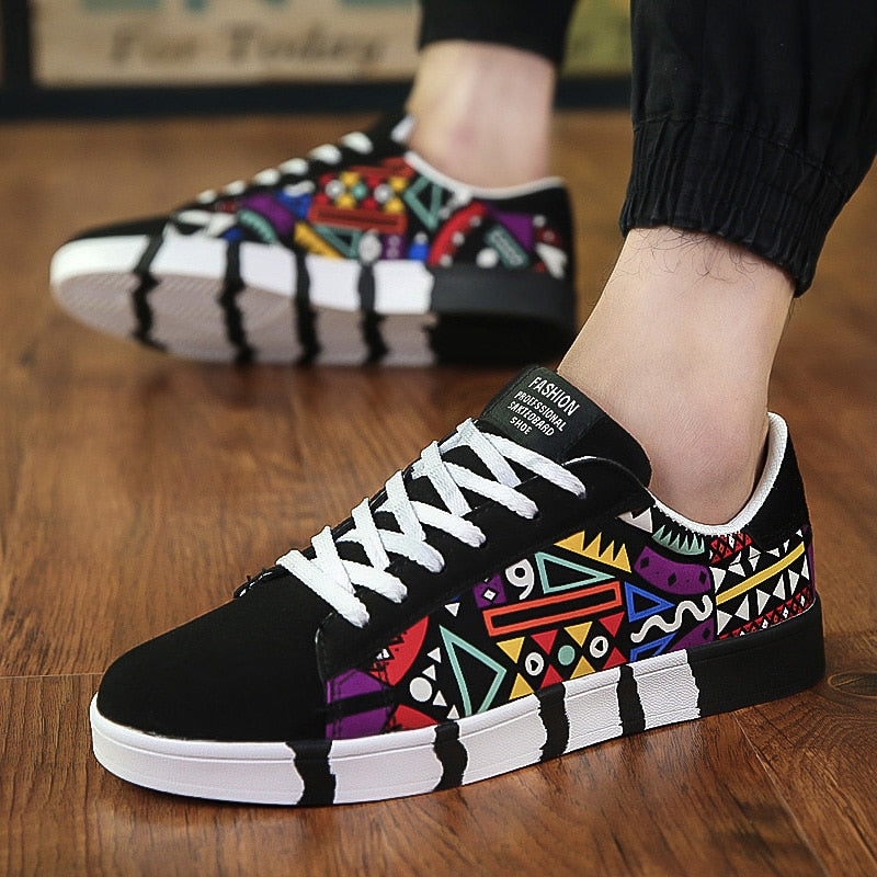 Trendy shoes canvas shoes featuring a black base with vibrant geometric patterns in red, purple, yellow, and blue, paired with white laces and a unique striped sole design.
